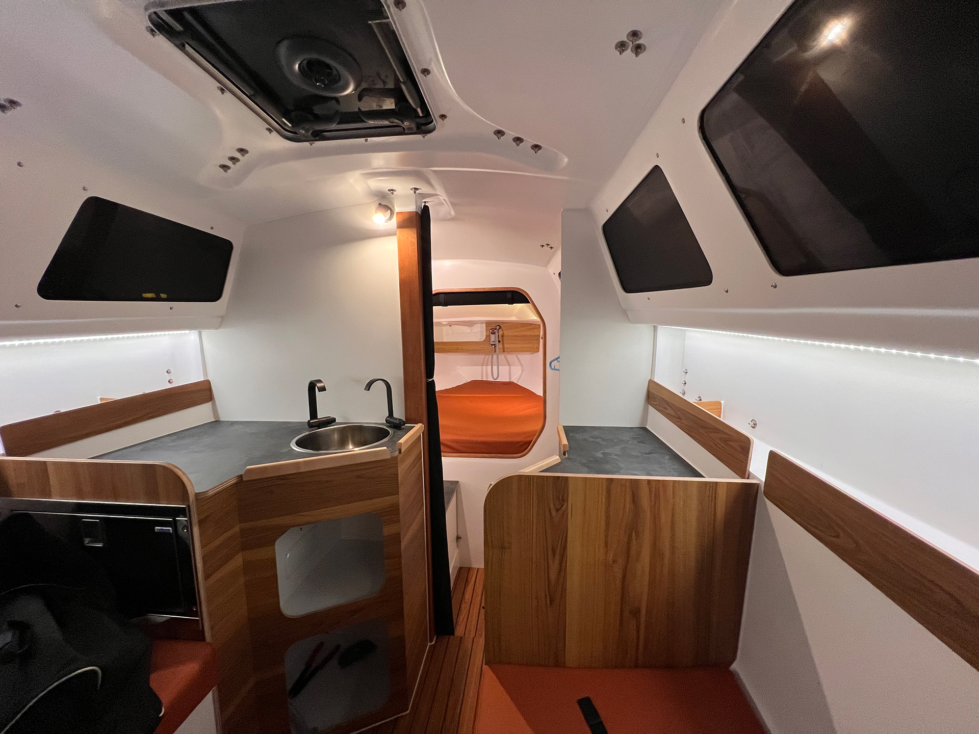 Interior of Tricat 8.50 showing sink and foward cabin with orange mattress